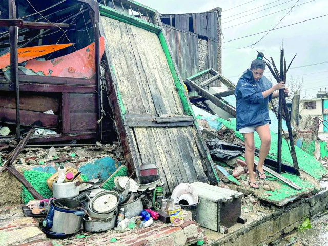 a woman salvages belongings from the rubble of her home after it collapsed during hurricane melissa s passage through santiago de cuba cuba photo afp a woman salvages belongings from the rubble of her home after it collapsed during hurricane melissa s passage through santiago de cuba cuba photo afp