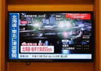 a tsunami warning flashes over live footage of a waterfront area on a television screen in sapporo in japan s northern hokkaido prefecture on december 9 2025 photo afp