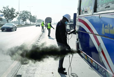 a technician examines a vehicle to test its emissions on a road on the outskirts of islamabad photo afp