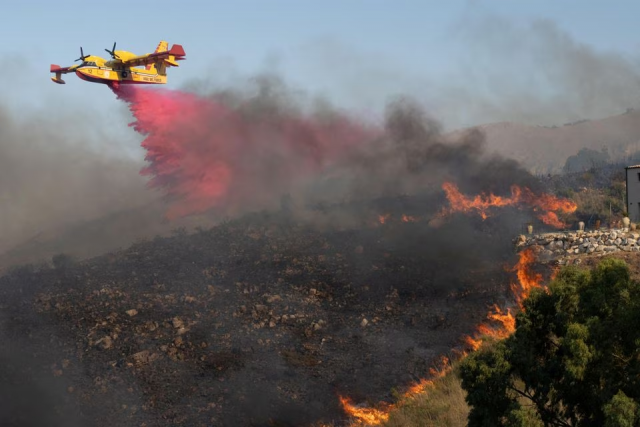 a canadair aircraft drops flame retardant on burning vegetation in sicily s trapani italy august 27 2023 photo reuters a canadair aircraft drops flame retardant on burning vegetation in sicily s trapani italy august 27 2023 photo reuters