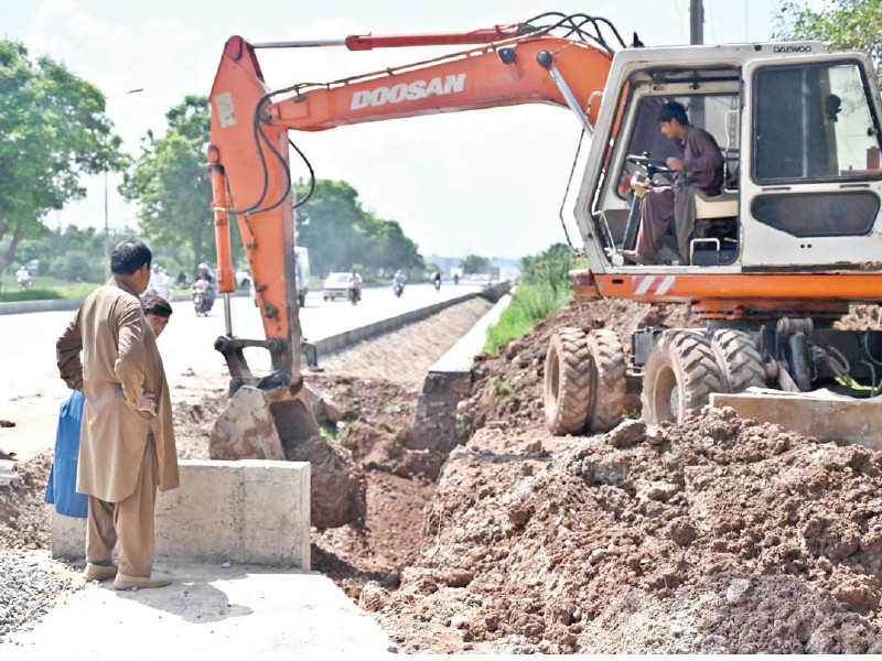 workers operate heavy machinery to facilitate the club road expansion in the federal capital photo app