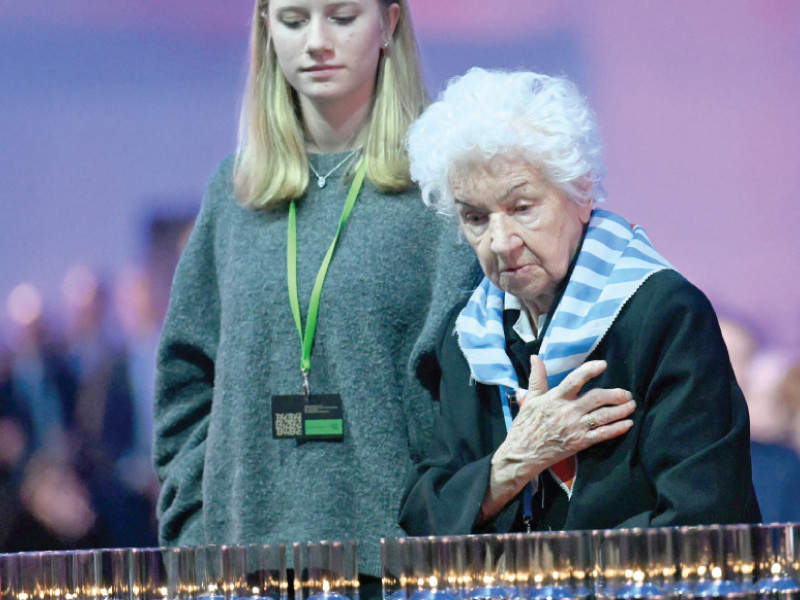 a survivor stands in front of votive candles to pay tribute to the victims during commemorations on the 80th anniversary of the liberation of the german nazi concentration and extermination camp at auschwitz birkenau by the red army in oswiecim poland photo afp