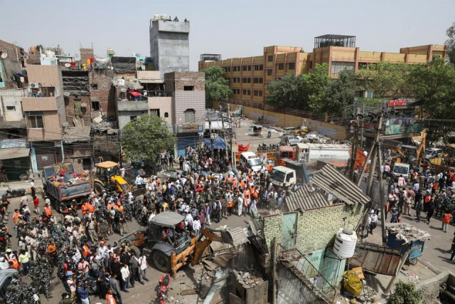 police officials and members of security forces oversee the demolition of small illegal retail shops by civic authorities in a communally sensitive area in jahangirpuri in new delhi india april 20 2022 reuters police officials and members of security forces oversee the demolition of small illegal retail shops by civic authorities in a communally sensitive area in jahangirpuri in new delhi india april 20 2022 reuters