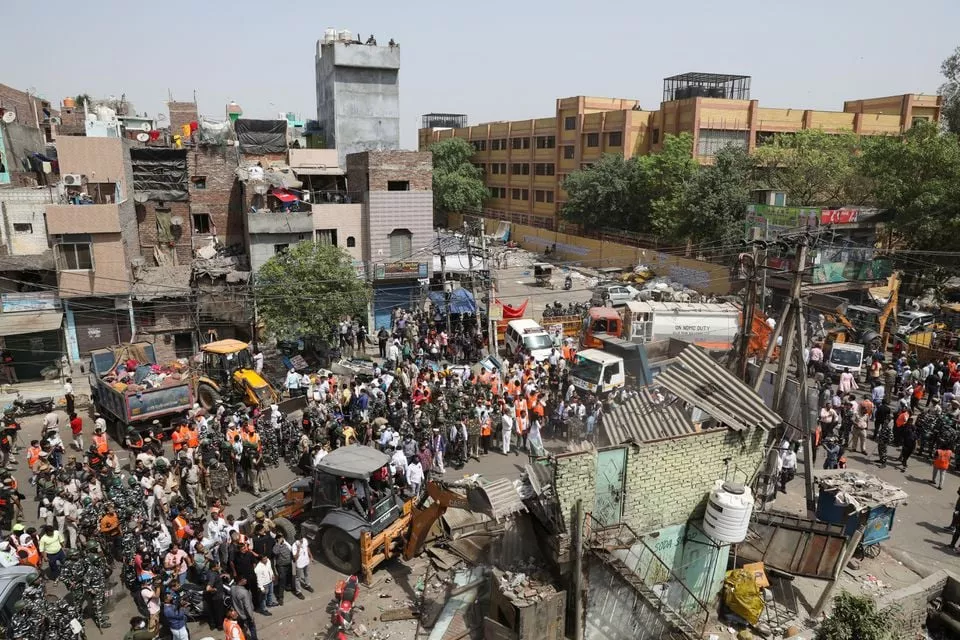 police officials and members of security forces oversee the demolition of small illegal retail shops by civic authorities in a communally sensitive area in jahangirpuri in new delhi india april 20 2022 reuters police officials and members of security forces oversee the demolition of small illegal retail shops by civic authorities in a communally sensitive area in jahangirpuri in new delhi india april 20 2022 reuters