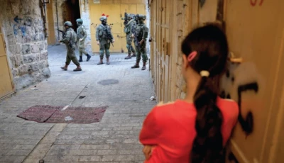 a palestinian girl waits to pass as israeli settlers take part in a weekly tour in hebron in the israeli occupied west bank reuters