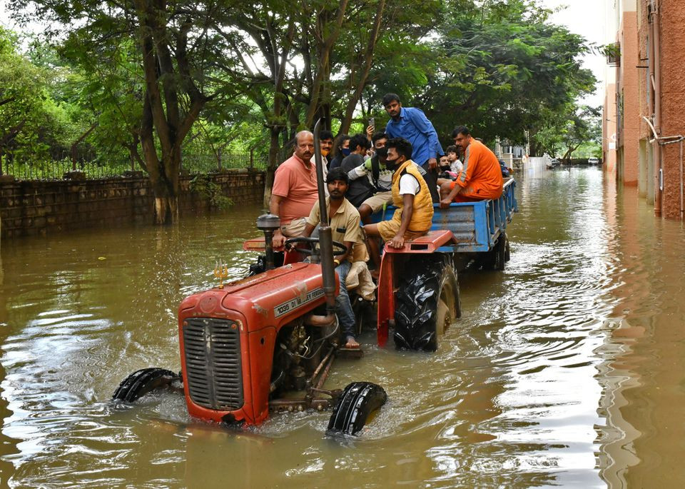 residents are evacuated to safer places in a tractor trolley after heavy rains caused flooding in a residential area in bengaluru india november 22 2021 reuters