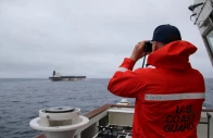 a u s coast guard official looks through binoculars at the ship marinera ex bella 1 in this handout image released january 7 2026 us european command via x handout via reuters a u s coast guard official looks through binoculars at the ship marinera ex bella 1 in this handout image released january 7 2026 us european command via x handout via reuters