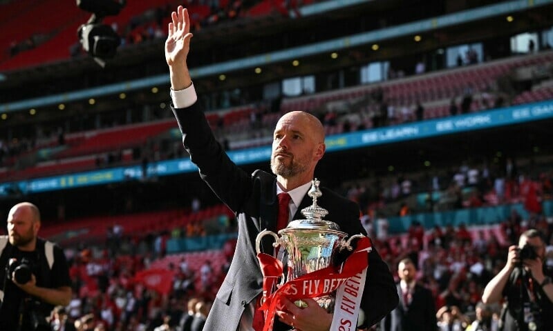 manchester united s dutch manager erik ten hag holds the trophy as he waves to the fans to celebrate their victory at the end of the english fa cup final football match between manchester city and manchester united at wembley stadium in london uk on may 25 2024 photo afp