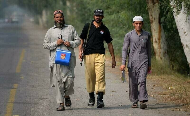 a file photo of polio workers in khyber pakhtunkhwa accompanied by a policeman photo reuters