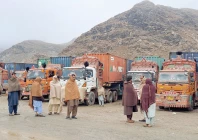 people stand next to parked trucks loaded with supplies at the torkham border crossing following a clash between pakistan and afghanistan photo reuters