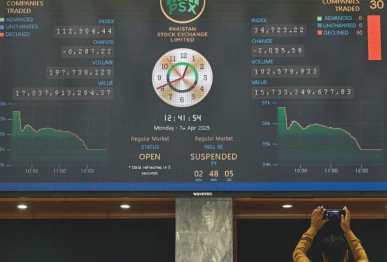 a broker monitors share prices displayed on a digital screen at the psx in karachi photo afp