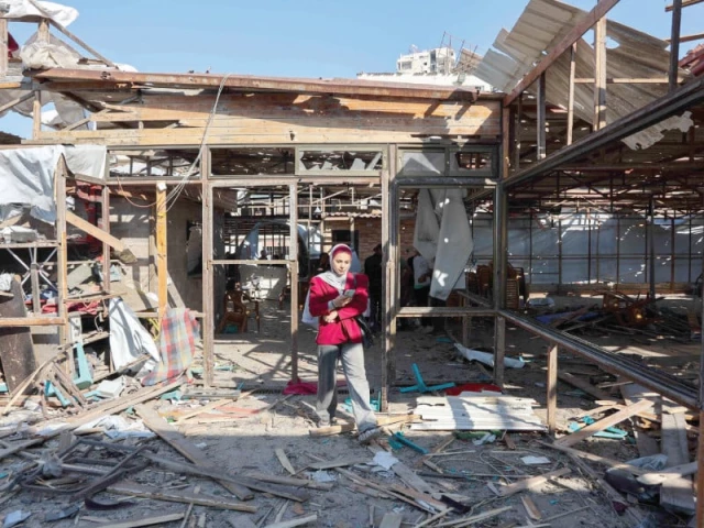 a woman walks on debris at al baqa cafeteria in gaza photo afp a woman walks on debris at al baqa cafeteria in gaza photo afp