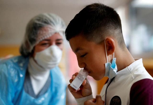 a schoolboy gives a sample during a covid 19 saliva test at lepeltier primary school in la trinite near nice amid the coronavirus disease covid 19 outbreak in france april 26 2021 photo reuters