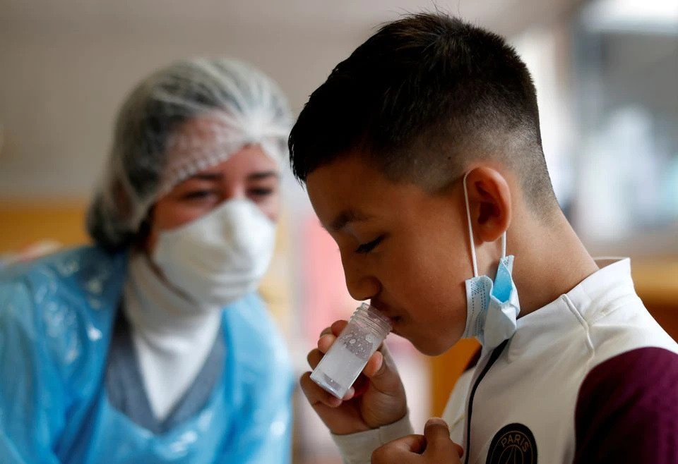 a schoolboy gives a sample during a covid 19 saliva test at lepeltier primary school in la trinite near nice amid the coronavirus disease covid 19 outbreak in france april 26 2021 photo reuters