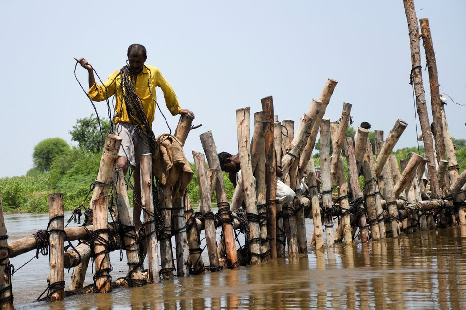 People prepare a barrier with wooden logs and sand bags to stop flood waters, following rains and floods during the monsoon season in Puran Dhoro, Badin, Pakistan August 30, 2022. REUTERS