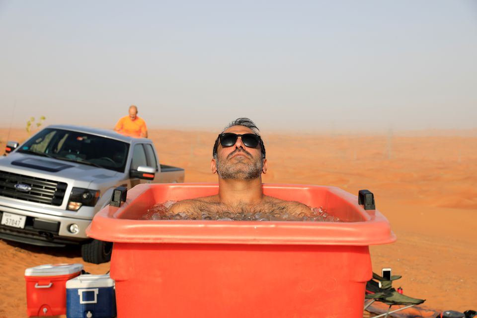 a participant sits in an ice bucket during an ice bath therapy session at the desert near sharjah united arab emirates june 25 2021 photo reuters