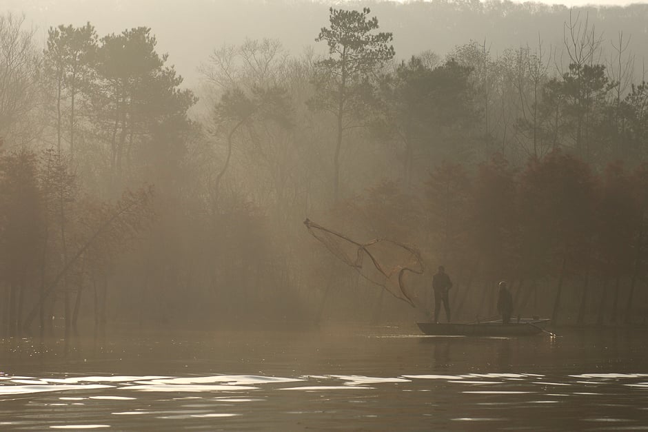 Fishermen cast their fishing net into a lake on a foggy day in Huai'an, Jiangsu province, China. PHOTO: REUTERS