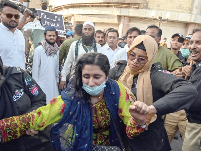 police detain an activist from the baloch yakjehti committee during a protest in karachi demanding the release of the group s chief organiser mahrang baloch along with other allegedly missing baloch persons photo afp