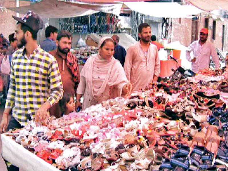 a woman sifts shoes on display at a shop to pick a perfect pair for her young daughter to flaunt on eidul azha the government has imposed a smart lockdown till august 5 as a strategy to prevent covid 19 resurge in the province photo rizwan anwar express