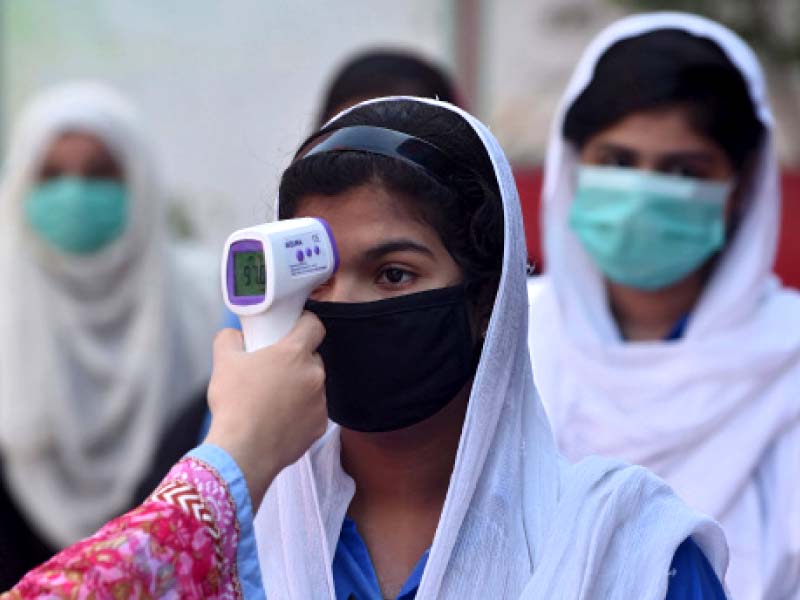 a school staffer checks the temperature of a student photo afp file