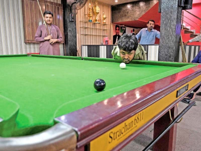 ikram uses only his chin to strike the cue ball on a snooker table photo afp