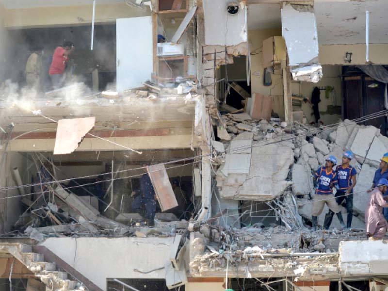 rescue workers search for victims trapped under the rubble of the residential building affected by a blast in gulshan e iqbal as debris falls from upper floors photo afp