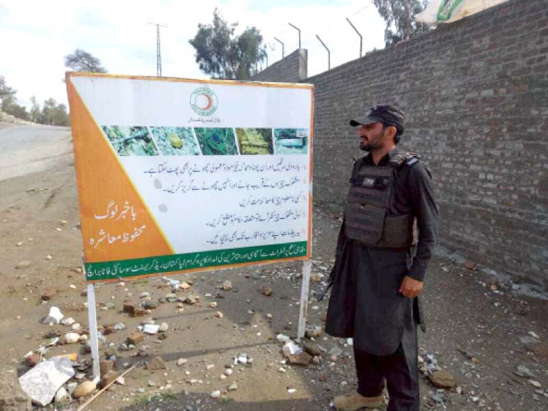 a policeman stands next to a signboard giving information about explosives in the area photo express