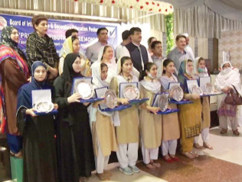 female students from peshawar pose with their shields after attaining top positions during bise exams photo express