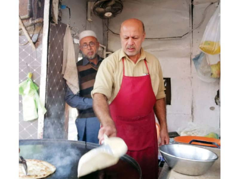 ishaq khan afridi cooks parathas for his customers at his shop in westridge rawalpindi photo express