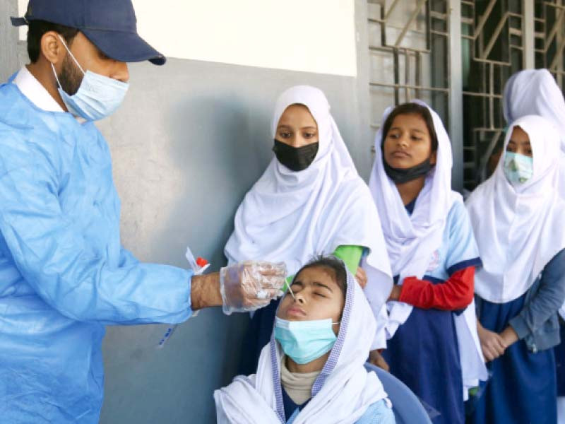 a health official conducts covid test of students at a government girls school in central district photo jalal qureshi express