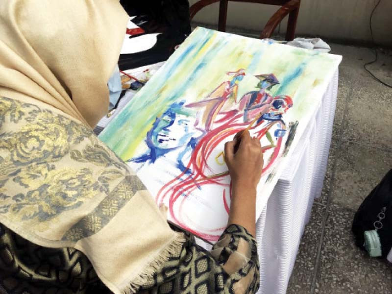a girl makes a painting during the art competition to highlight women s issues photo express