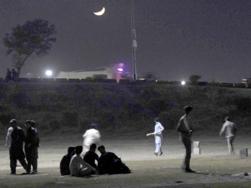 youngsters play a riveting game of night cricket under the streetlights next to the faizabad interchange in islamabad photo online