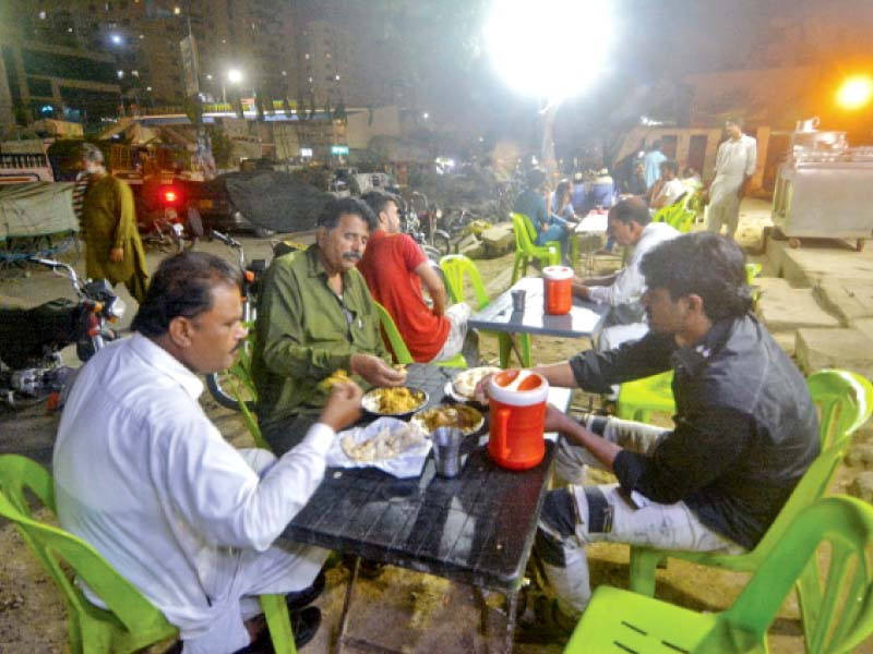 people dine out in the cool evening breeze in karachi on thursday many eateries stay open till sehri to serve people enjoying dining out   the only nightlife permissible in the country photo express