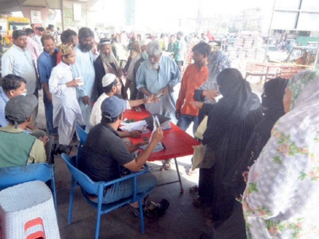 people line up to receive ramazan ration bags from the camp of a charity organisation under the kpt flyover in karachi photo express people line up to receive ramazan ration bags from the camp of a charity organisation under the kpt flyover in karachi photo express