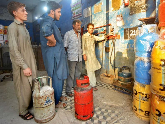 people stand in line for refilling lpg cylinders at a decanting shop the shopkeeper has also put on sale the new fibre glass rust and leak proof lpg cylinders in view of rising demand photo jalal qureshi