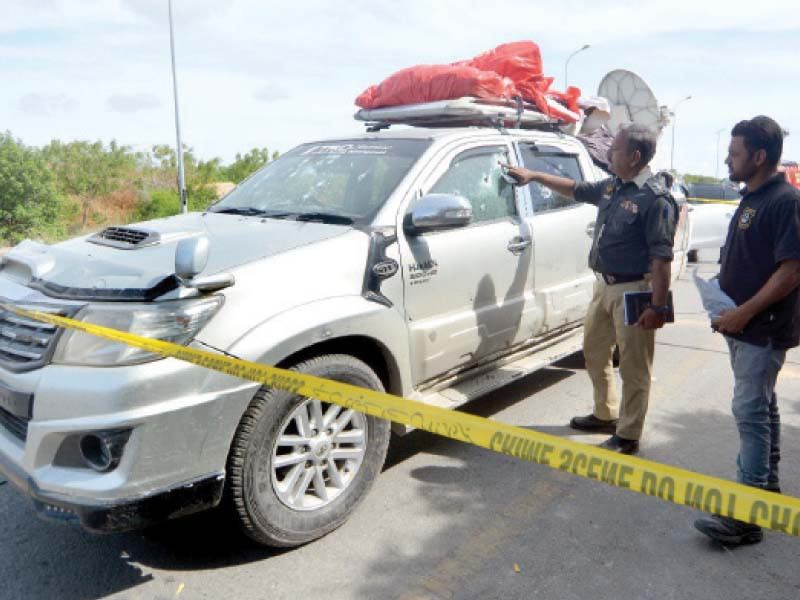 a police officer and an official of the crime scene unit inspect the vehicle in which mpa aslam abro s brother and nephew were killed photo jalal qureshi express