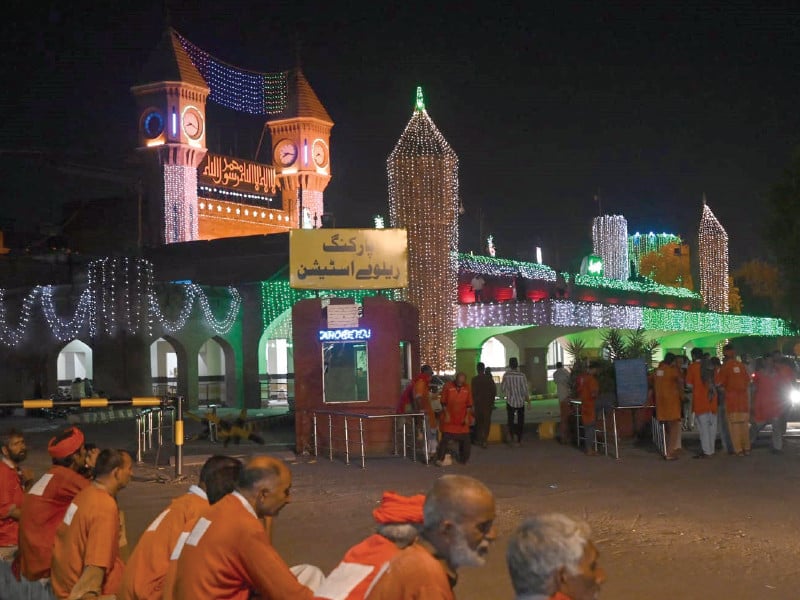 porters wait for passengers outside the lahore railway station colourfully illuminated on the eve of the independence day photo express mehmood qureshi