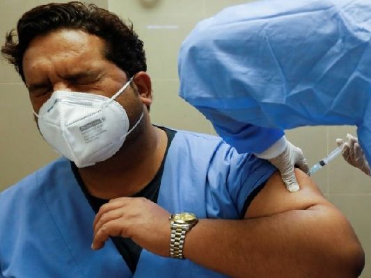 a health worker reacts while receiving a dose of the sinopharm vaccine donated by china at a vaccination centre in karachi on february 3 2021 reuters file