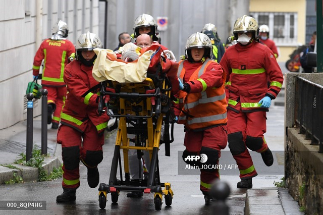 french firefighters push a gurney carrying an injured person near the former offices of the french satirical magazine charlie hebdo following an alleged attack by a man wielding a machete in paris on september 25 2020 the threats coincide with the trial of 14 suspected accomplices of the perpetrators of the massacres at charlie hebdo and a jewish supermarket that left a total of 17 dead photo afp