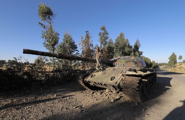 a boy sits on the barrel of a military tank destroyed recently during fighting between the ethiopian national defense force endf and the tigray people s liberation front tplf in damot kebele of amhara region ethiopia december 7 2021 picture taken december 7 2021 photo reuters