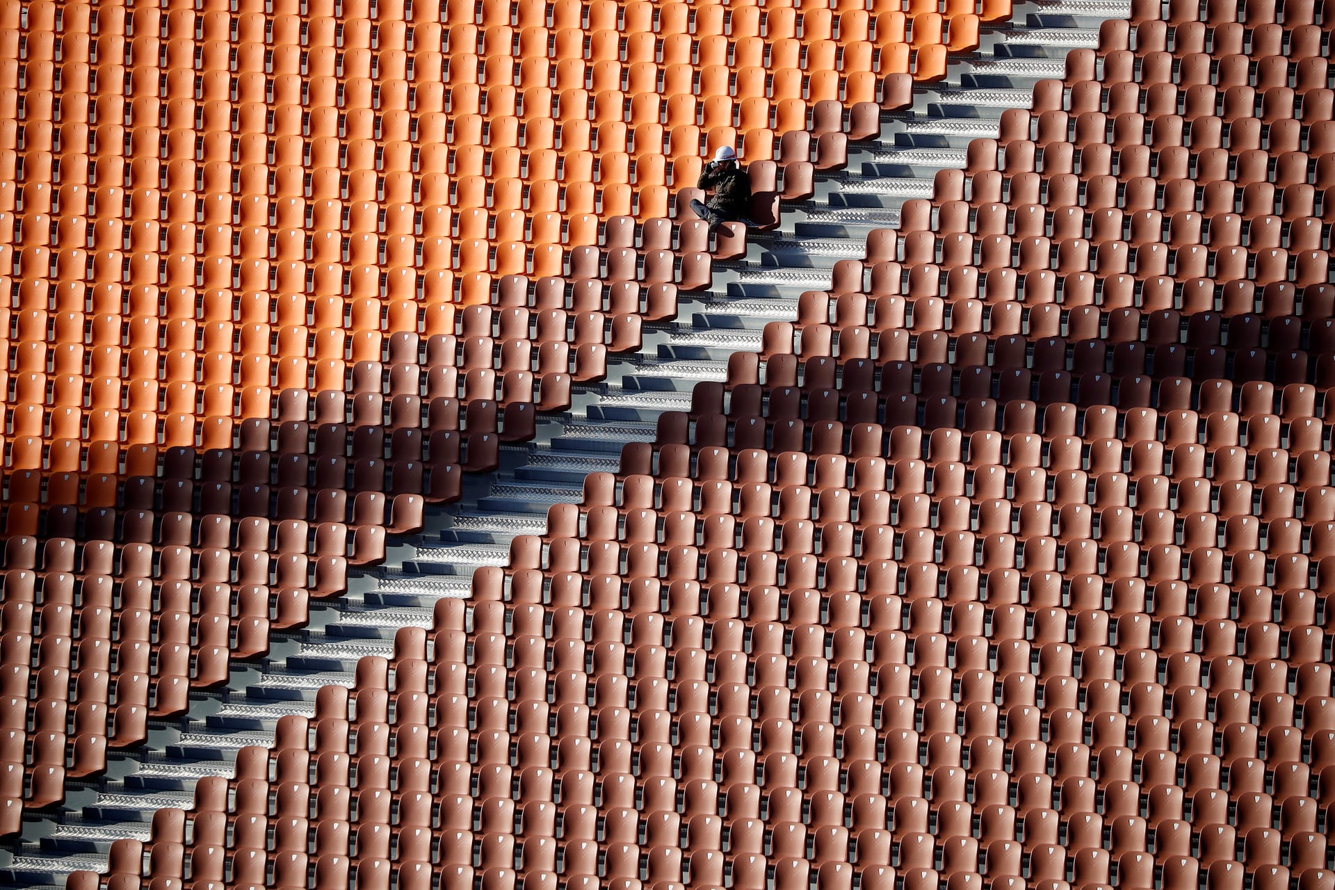 a worker rests on a seat at the olympic plaza the venue for the opening ceremony of the 2018 winter olympic games pyeongchang south korea photo reuters