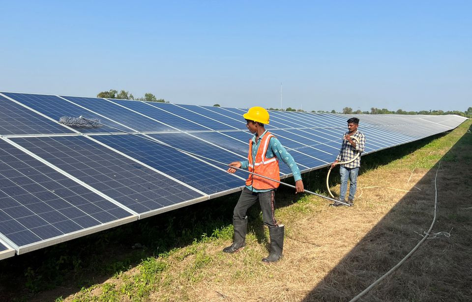 workers clean panels at a solar park in modhera india s first round the clock solar powered village in the western state of gujarat india october 19 2022 reuters