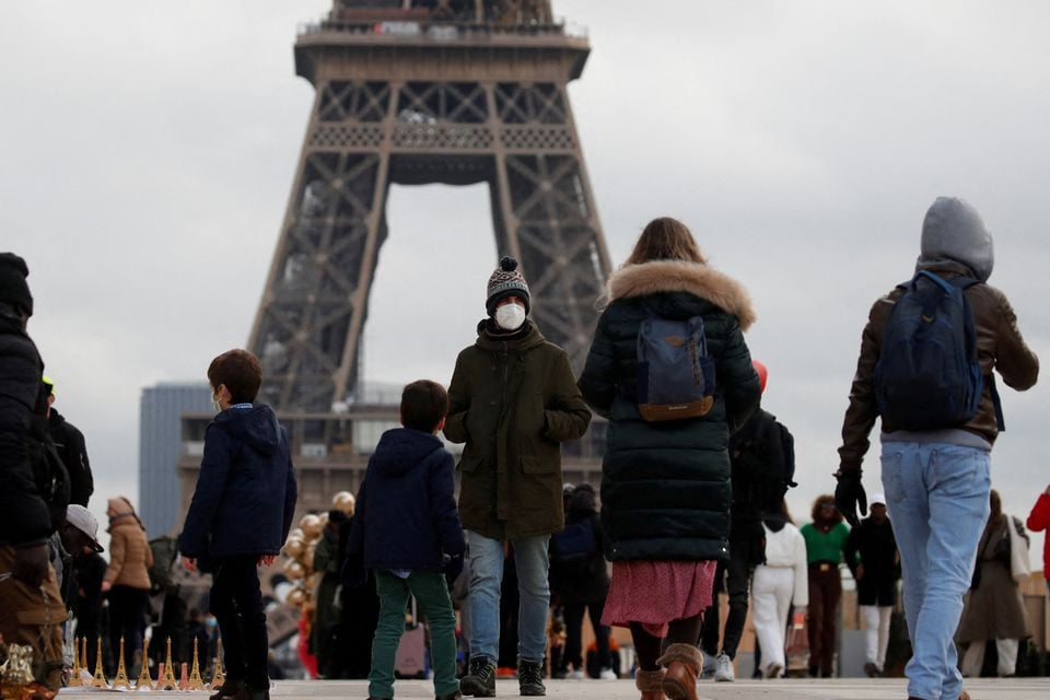 people wearing protective face masks walk on trocadero square near the eiffel tower in paris amid the coronavirus disease covid 19 outbreak in france december 6 2021 photo reuters