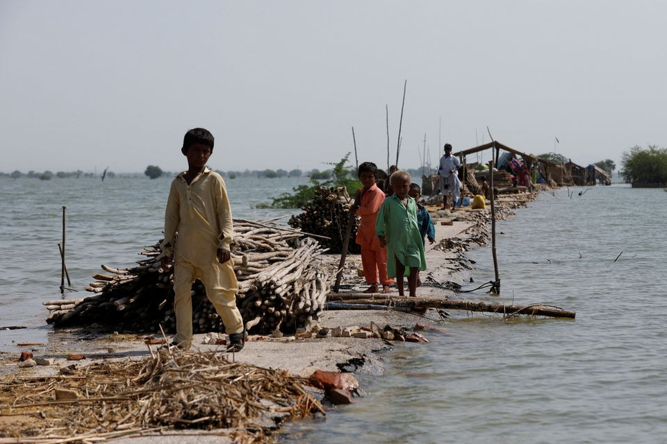 children stand as their family takes refuge along a damaged road amid flood following rains and floods during the monsoon season in bajara village at the banks of manchar lake in sehwan pakistan september 6 2022 reuters akhtar soomro file photo