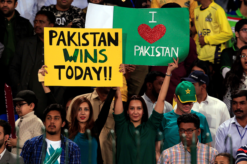 Pakistani spectators hold placards at Gaddafi Cricket Stadium as they wait for the start of a hugely anticipated finals of its domestic cricket league. PHOTO: REUTERS