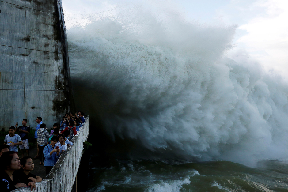 People watch as Hoa Binh hydroelectric power plant opens the flood gates after a heavy rainfall caused by a tropical depression in Hoa Binh province, outside Hanoi, Vietnam. PHOTO: REUTERS