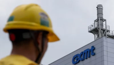a man wearing a yellow protective helmet walks next to a production facility of china s top memory chipmaker cxmt with company s logo on the facade in beijing china july 29 2026 reuters