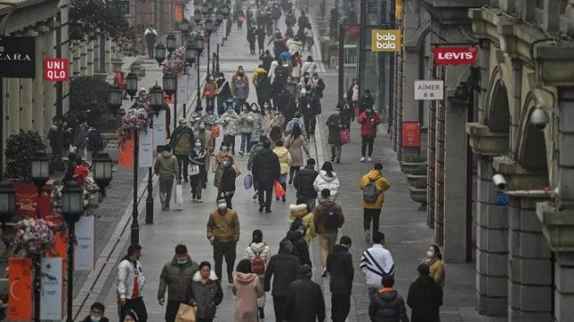 people walk along a street in wuhan on saturday one year after the city went into lockdown to curb the spread of covid 19 photo afp people walk along a street in wuhan on saturday one year after the city went into lockdown to curb the spread of covid 19 photo afp