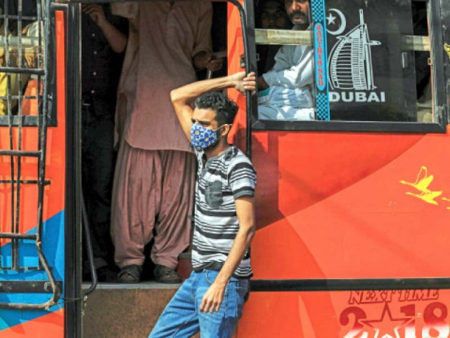 a man wears a face mask as he stands at the door of a public bus while another passenger peers out without one though covid 19 cases have been rising exponentially observance of precautions has been patchy photo reuters a man wears a face mask as he stands at the door of a public bus while another passenger peers out without one though covid 19 cases have been rising exponentially observance of precautions has been patchy photo reuters