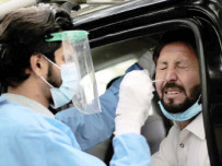 a paramedic uses a swab to take a nasal sample as he conducts a novel coronavirus test at a roadside testing facility in islamabad photo nni